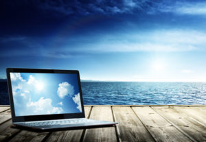 Clouds on Laptop on pier and atlantic ocean